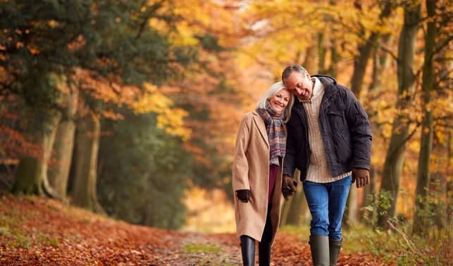 a mature couple over 50 having a walk in a park together