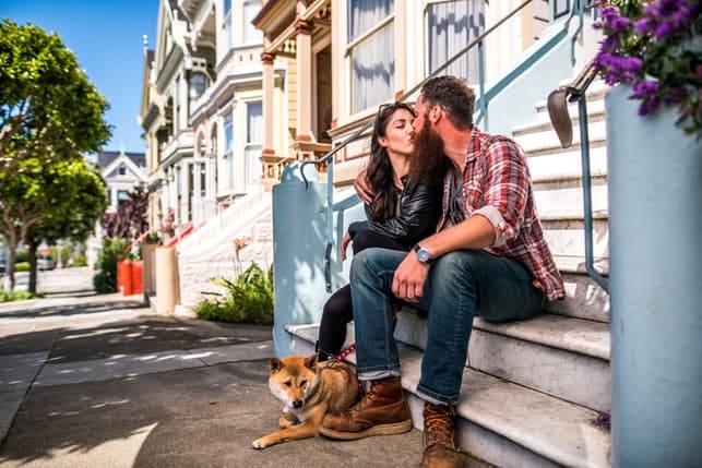 couple kissing next to a fancy house