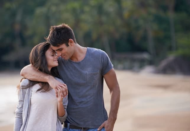 a young couple in love walking on the beach