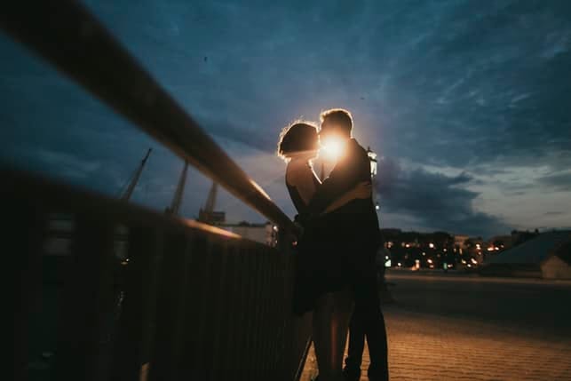 a couple kissing romantically at night outdoors