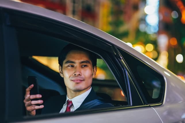 a portrait of an Asian businessman in a car