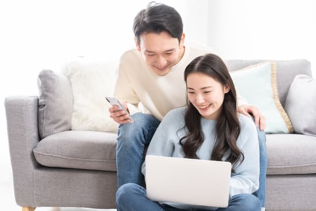 an Asian couple using a laptop together