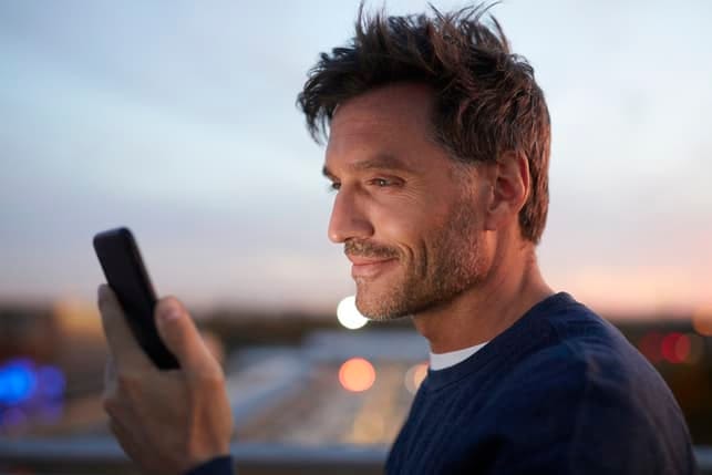 a man checking his smartphone and smiling