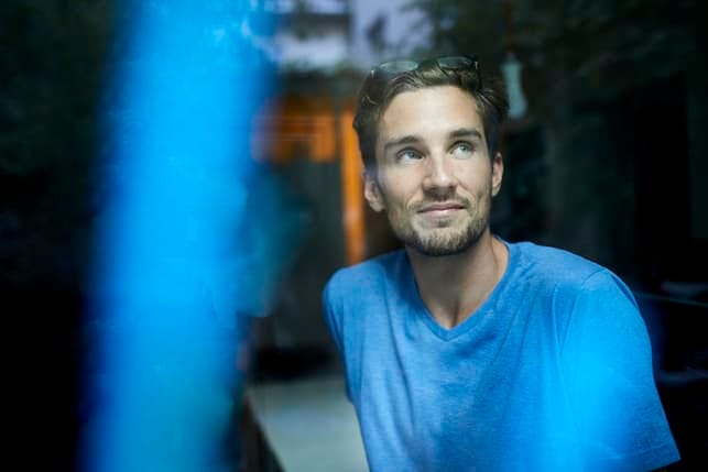 a portrait of a man in a blue sweater