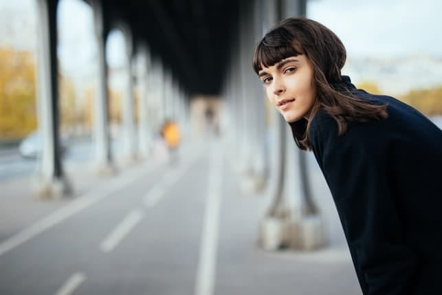 a young girl posing under the bridge