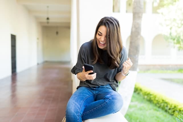a happy woman reading a text message