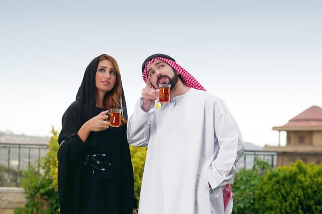 a Muslim couple drinking tea together outdoors
