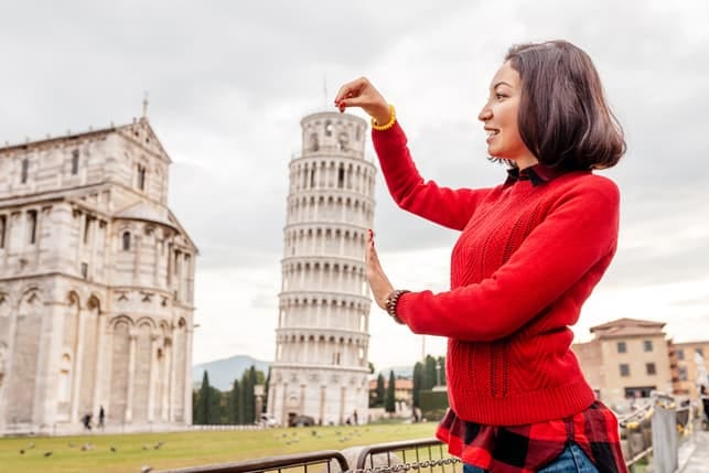 an asian woman posing with a Pisa tower