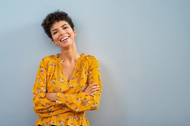 a young black woman in yellow posing and smiling