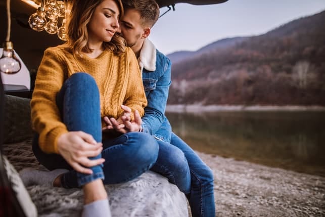 a couple hugging while camping in the autumn