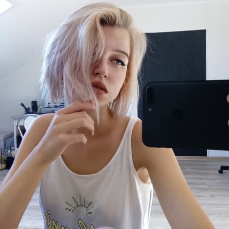 a young blonde girl taking a selfie in the mirror