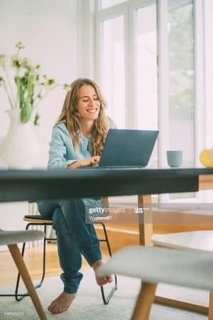 a blonde curly girl using her laptop