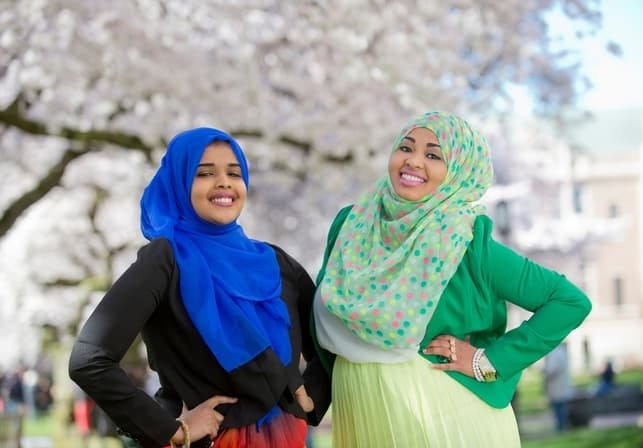 two young women in traditional clothing posing outdoors