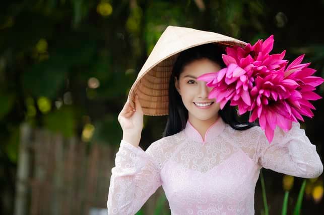 a charming Asian girl in traditional dress with flowers