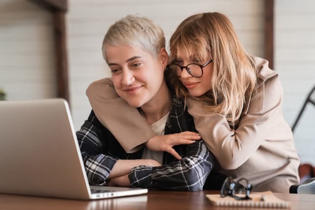 a lesbian couple using a laptop together