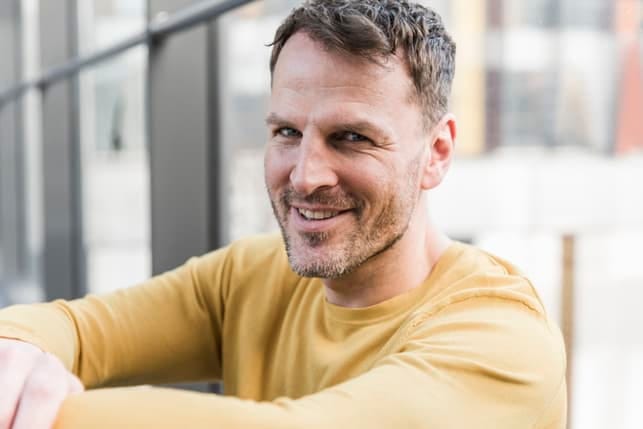 a portrait of a man in a yellow T-shirt