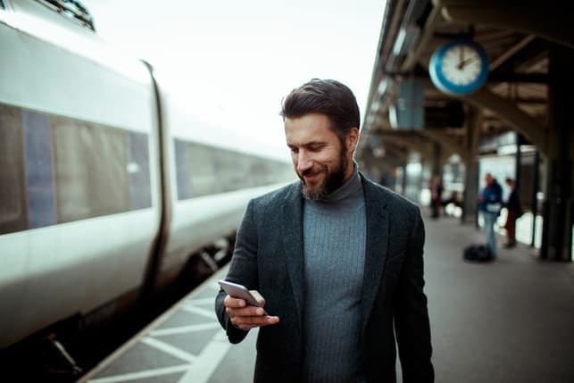a bearded man checking his smartphone