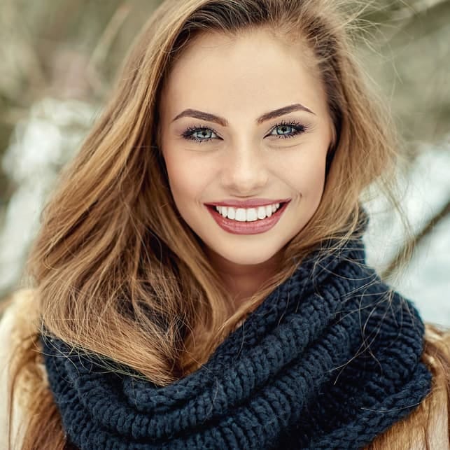 a beautiful blonde woman smiling and posing for a portrait