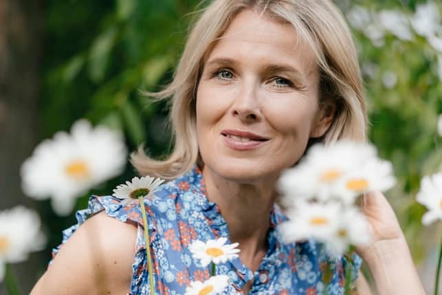 a woman over 50 posing outdoors