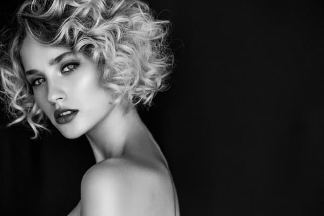 a portrait of a beautiful curly blonde woman in black-and-white