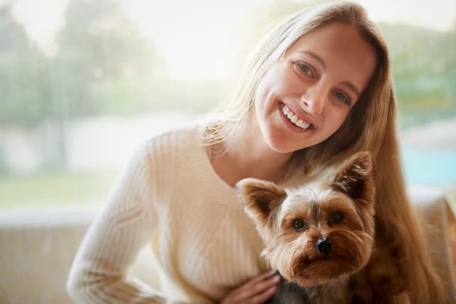 a young woman with a dog smiling