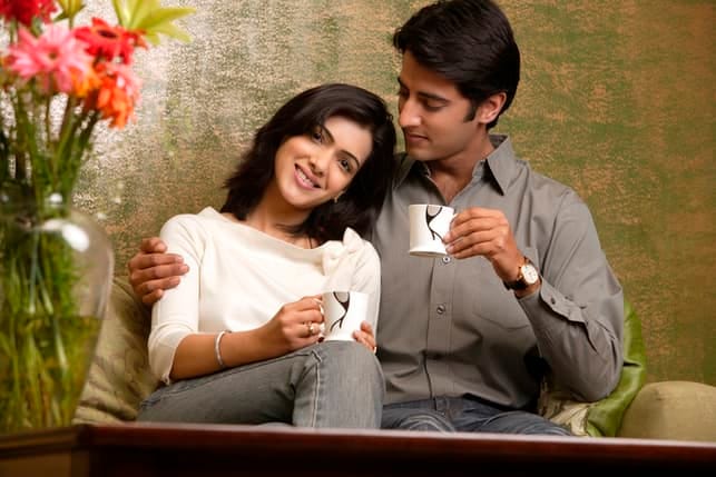 an oriental couple enjoying their coffee together while hugging