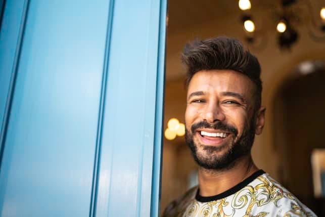 a young man smiling in camera indoors